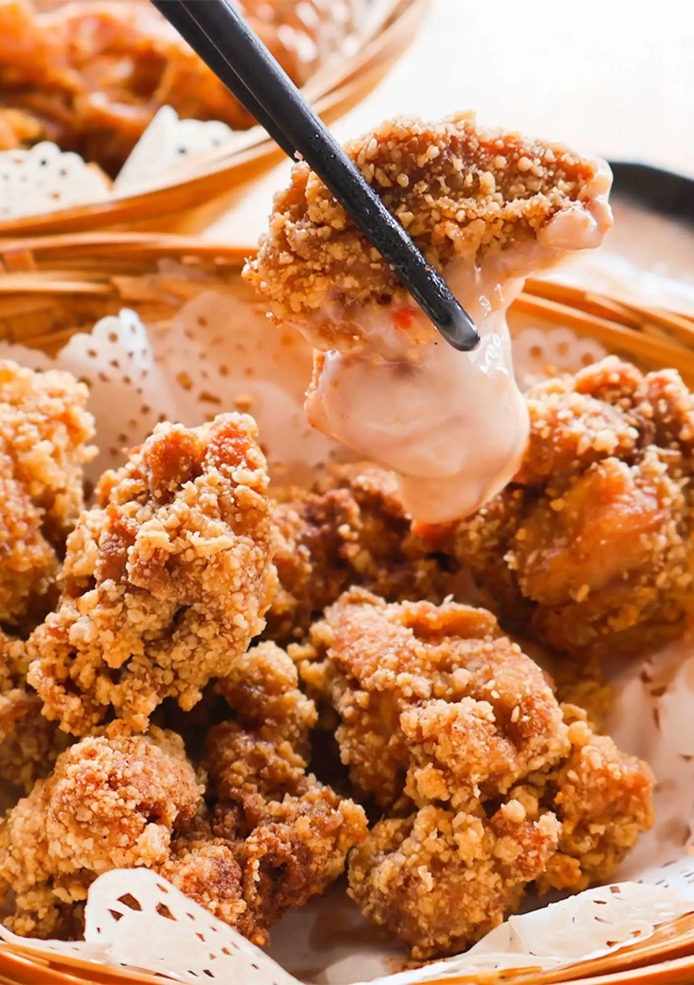 Crispy fried chicken pieces being dipped in creamy sauce, perfect side dish for Sabah chilli pan mee